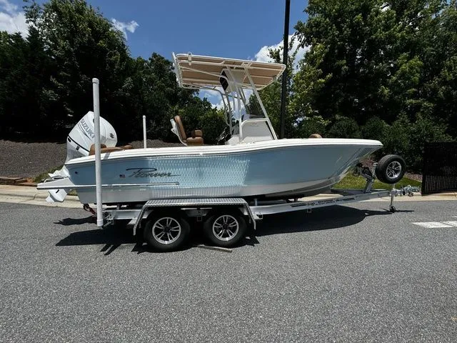 The Image of 2025 Pioneer ISLANDER 202 boat on trailer, parked outdoors, sunny day. - 1