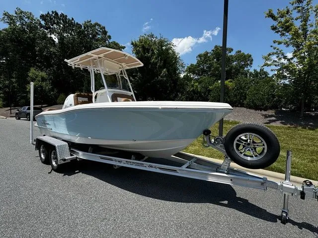 Slide: The Image of 2025 Pioneer ISLANDER 202 boat on trailer, parked outdoors under clear sky. - 2