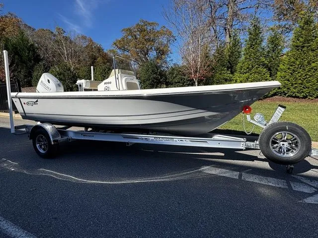 Slide: The Image of 2025 Bulls Bay 2000 boat on trailer, parked on road, surrounded by trees. - 2