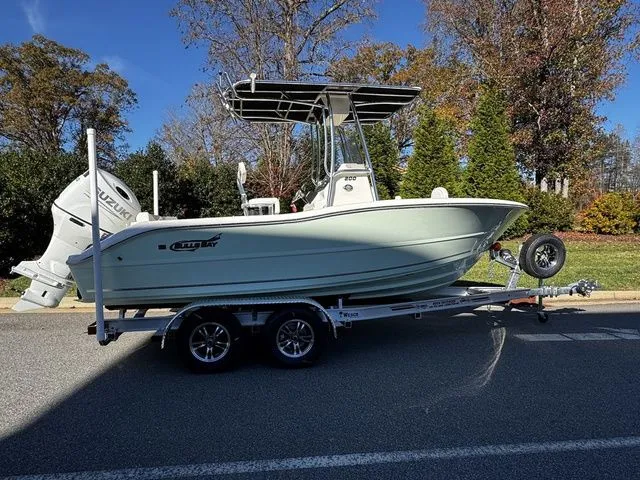 The Image of 2025 Bulls Bay 200CC boat on trailer, parked on a road with trees in the background. - 1