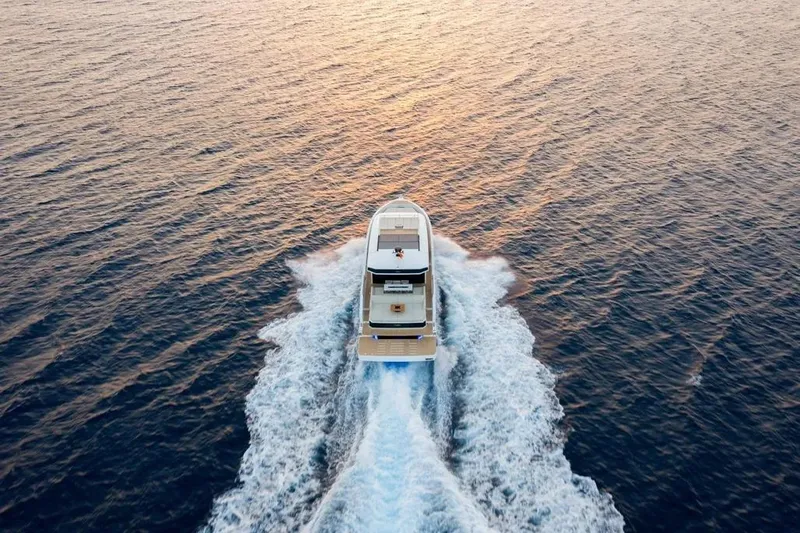Slide: The Image of Aerial view of 2026 De Antonio Yachts D60 cruising on open water at sunset. - 5
