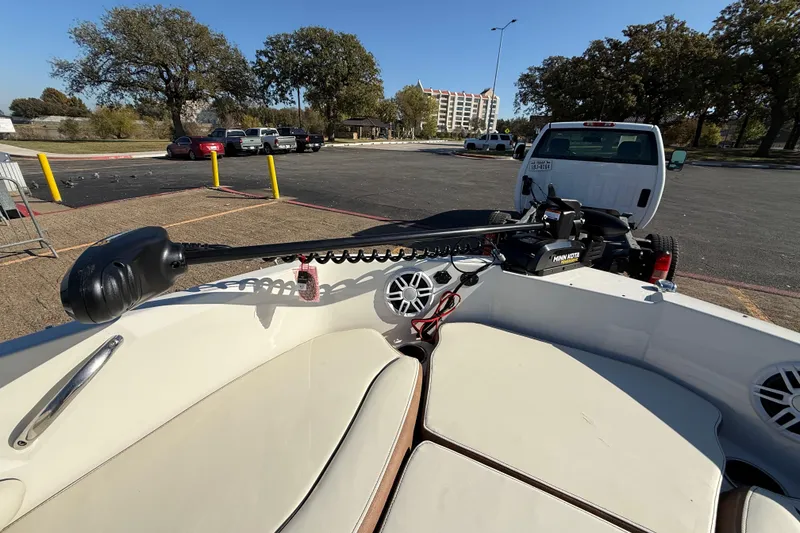 Slide: The Image of 2023 Stingray 192 DC boat interior with speakers and trolling motor, parked on a trailer. - 25