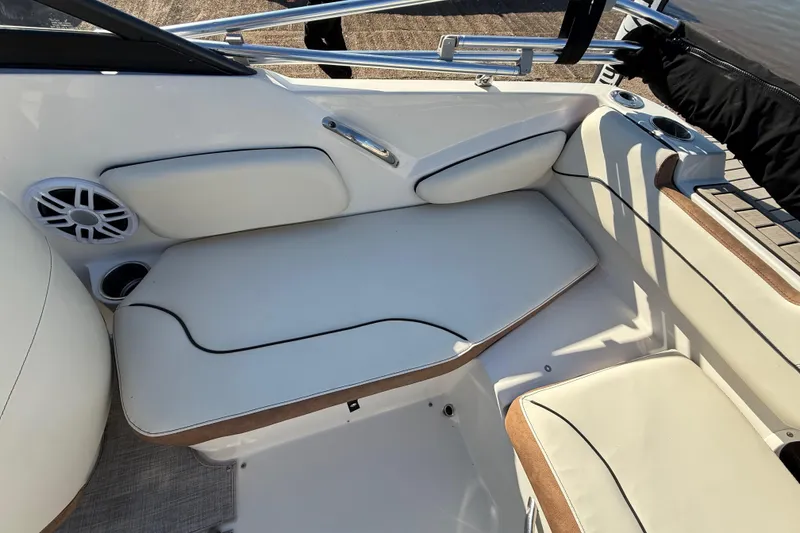 Slide: The Image of 2023 Stingray 192 DC boat interior with beige and brown seating, cup holders, and speaker. - 33