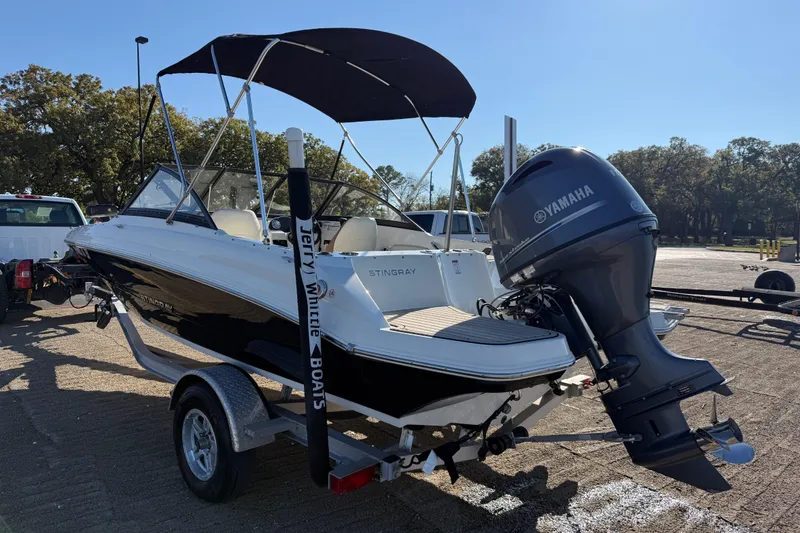 Slide: The Image of 2023 Stingray 192 DC boat with outboard motor, parked on a sunny day. - 51