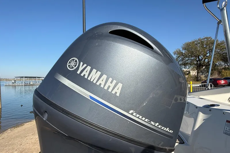 Slide: The Image of 2023 Stingray 192 DC boat on trailer by the water, under clear blue sky. - 59