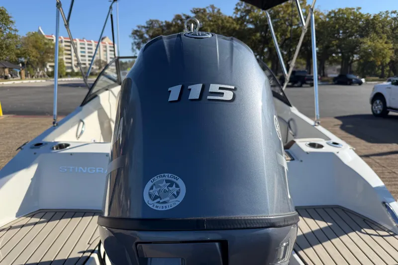 Slide: The Image of 2023 Stingray 192 DC boat on trailer by the water, featuring a sleek black and white design. - 60