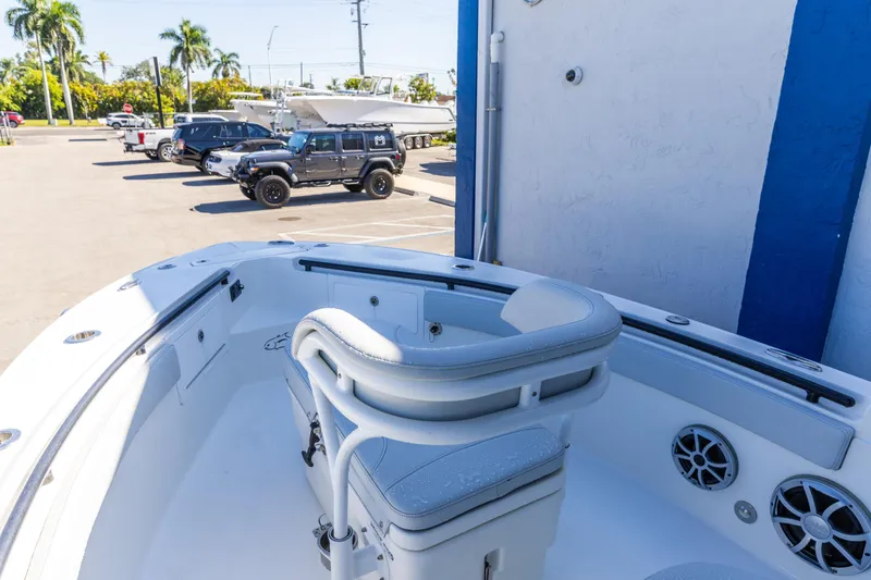 Slide: The Image of 2018 Crevalle 26 Open boat interior with seating, parked cars in background. - 14