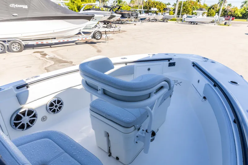 Slide: The Image of 2018 Crevalle 26 Open boat interior with seating and speakers in a sunny marina. - 7