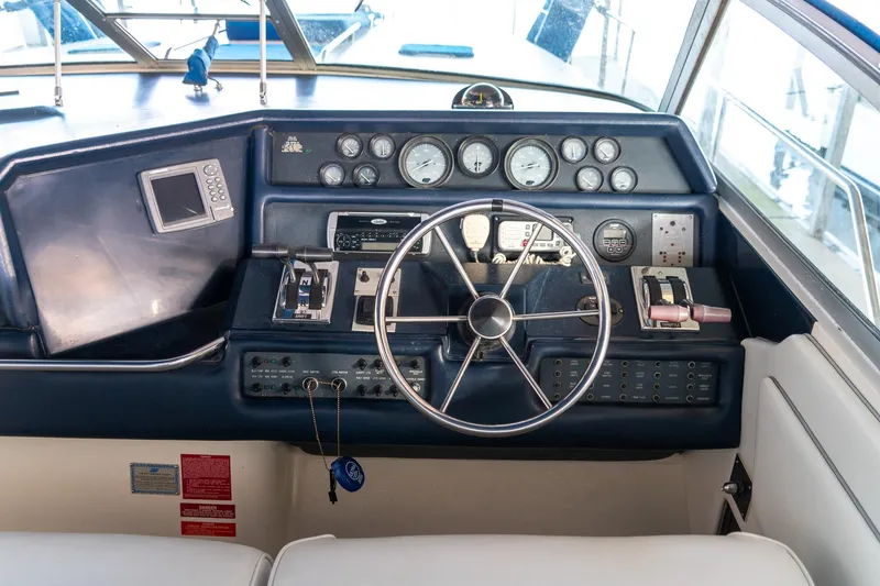 Slide: The Image of 1991 Sea Ray 350 Sundancer helm with steering wheel, gauges, and controls. - 18