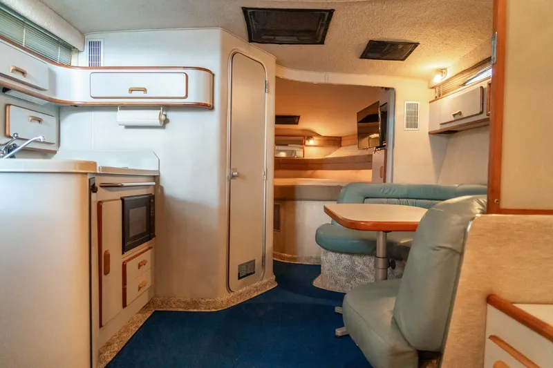 Slide: The Image of Interior of a 1991 Sea Ray 350 Sundancer yacht with kitchen and seating area. - 21