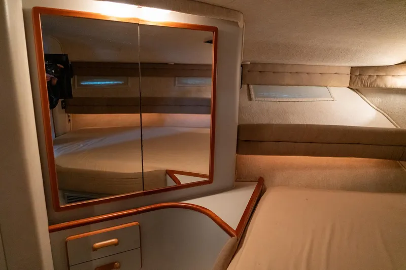 Slide: The Image of 1991 Sea Ray 350 Sundancer cabin interior with mirror and cozy bed. - 24