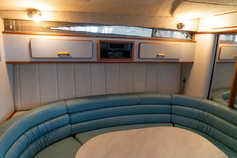 Slide: The Image of 1991 Sea Ray 350 Sundancer interior with curved seating and overhead storage. - 26