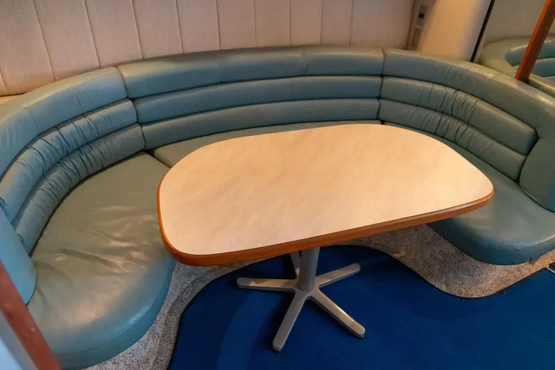 Slide: The Image of 1991 Sea Ray 350 Sundancer interior with blue leather seating and a central table. - 27