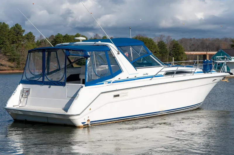 Slide: The Image of 1991 Sea Ray 350 Sundancer boat on a calm lake with trees in the background. - 6