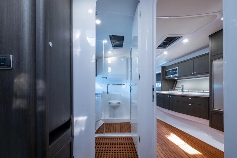 Slide: The Image of Luxurious interior of 2024 Intrepid 477 Evolution yacht, featuring modern kitchen and bathroom. - 13
