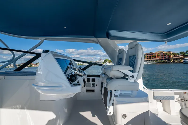 Slide: The Image of 2024 Intrepid 477 Evolution yacht helm with luxurious seating and modern controls. - 27