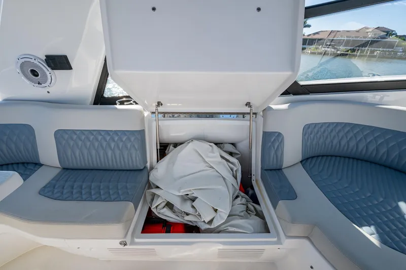 Slide: The Image of 2024 Intrepid 477 Evolution boat interior with open storage compartment and cushioned seating. - 35