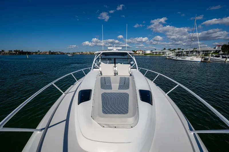 Slide: The Image of 2024 Intrepid 477 Evolution yacht on calm water under a clear blue sky. - 44