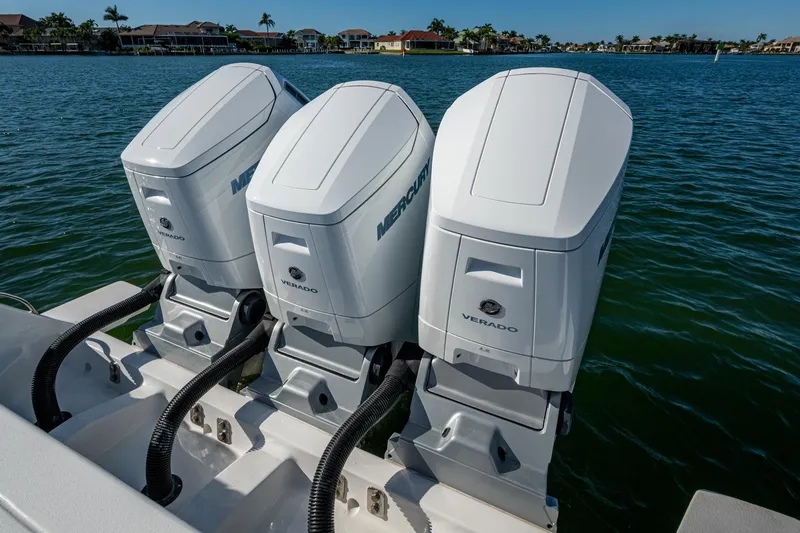 Slide: The Image of Triple Mercury Verado engines on 2024 Intrepid 477 Evolution boat, docked on calm water. - 50