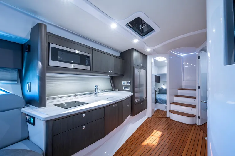 Slide: The Image of Luxurious 2024 Intrepid 477 Evolution yacht interior with modern kitchen and wooden flooring. - 9
