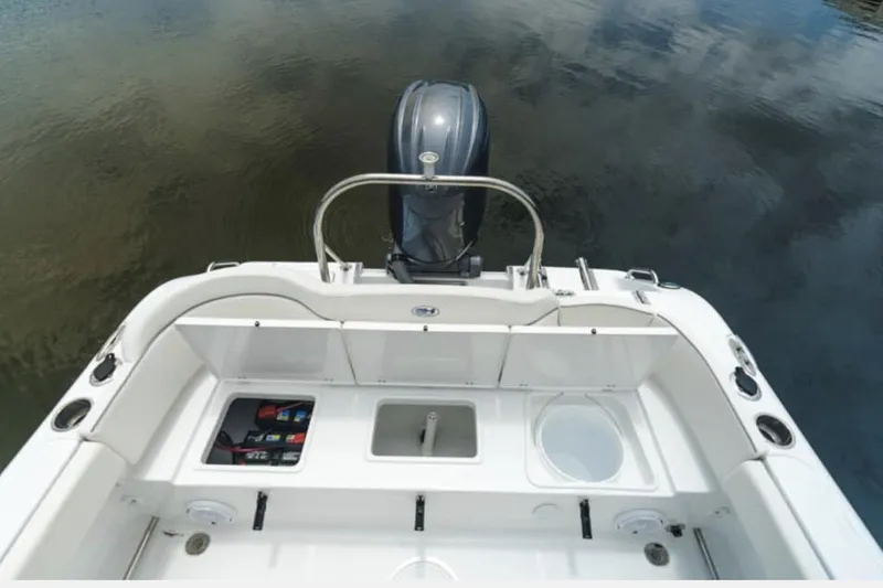 Slide: The Image of Manufacturer Provided Image: 2026 Sea Hunt Ultra 229 boat stern with motor, storage compartments, and rod holders. - 6