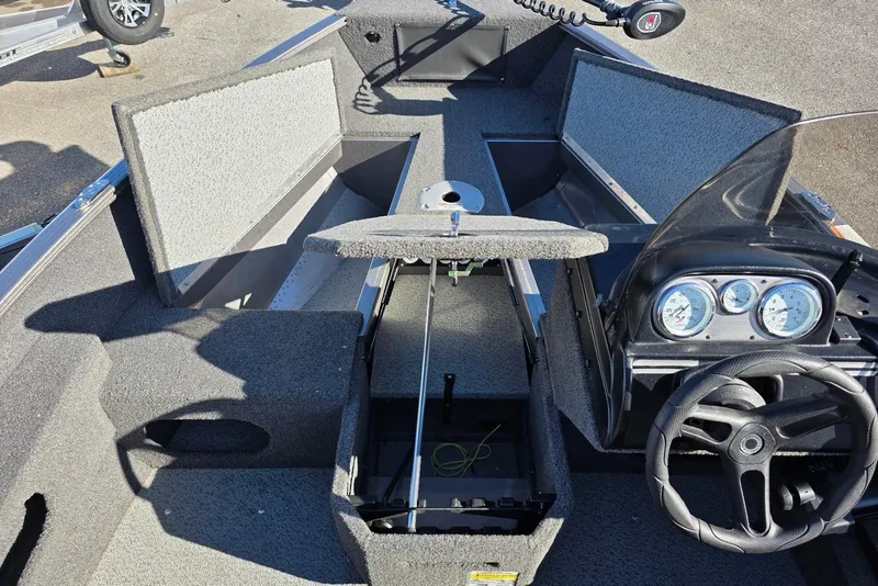 Slide: The Image of 2022 Lund 1675 Adventure SS boat interior with open storage compartments and steering console. - 10