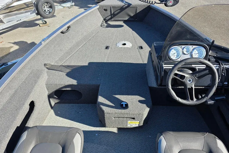 Slide: The Image of 2022 Lund 1675 Adventure SS boat interior with steering wheel and dashboard gauges. - 9