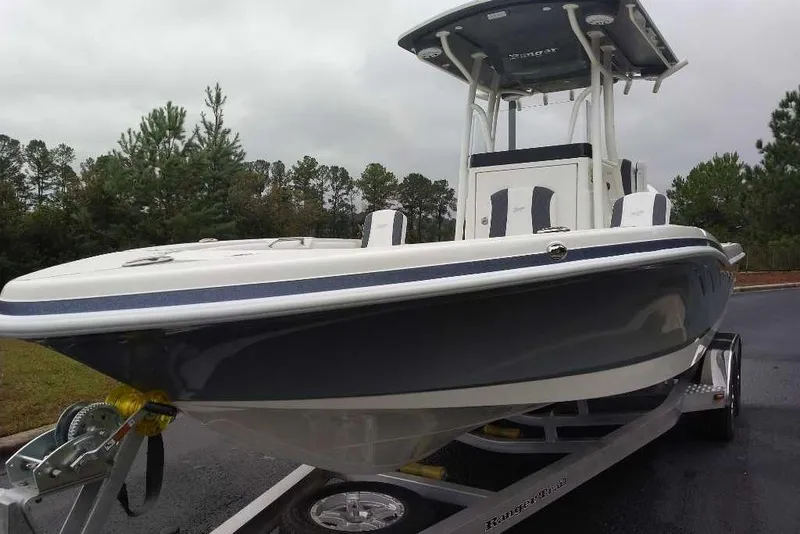 Slide: The Image of 2026 Ranger 2660 Bay boat on trailer, parked outdoors with trees in background. - 4
