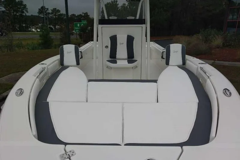 Slide: The Image of 2026 Ranger 2660 Bay boat interior with white and gray seating, parked outdoors. - 9