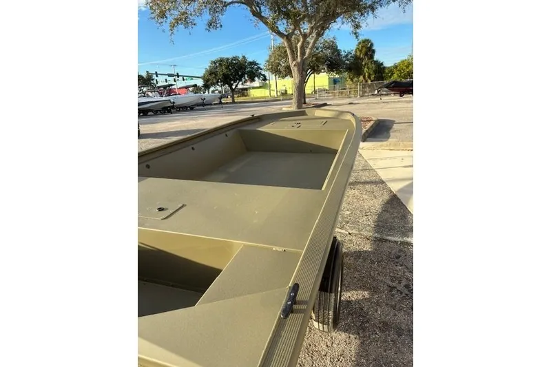 Slide: The Image of 2026 Tracker Grizzly 1648 Utility boat in a parking lot, under a tree. - 3
