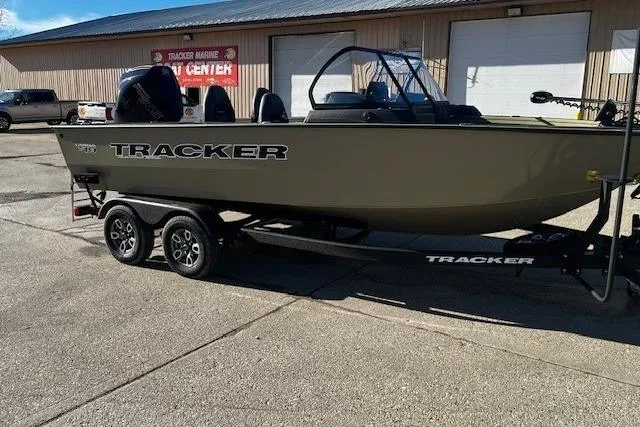 Slide: The Image of 2026 Tracker Targa V-19 Combo boat on trailer, parked outside a marine center. - 68