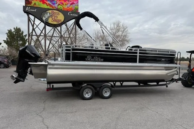 Slide: The Image of 2026 Sun Tracker SportFish 22 XP3 pontoon boat on trailer near Bass Pro Shops. - 3