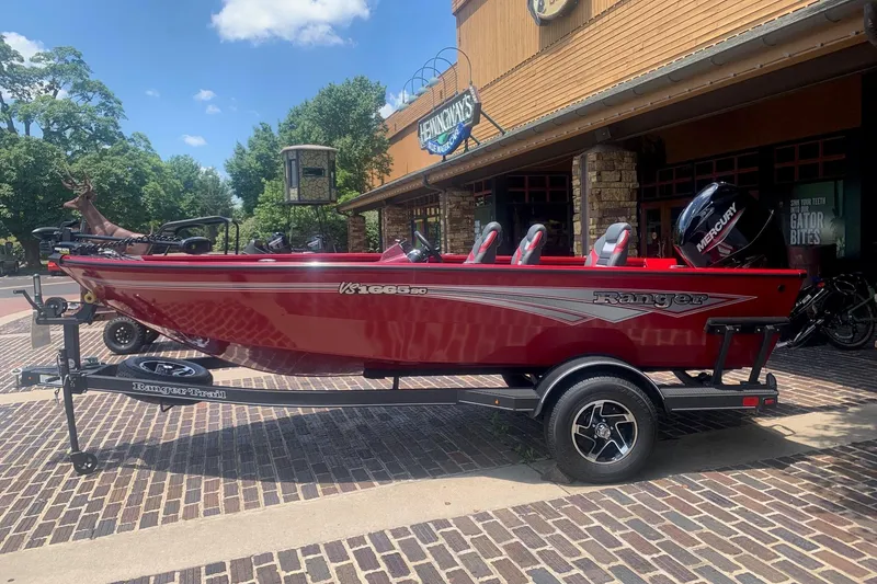 The Image of Red 2026 Ranger VS1665SC boat on trailer, parked outside a rustic building. - 0