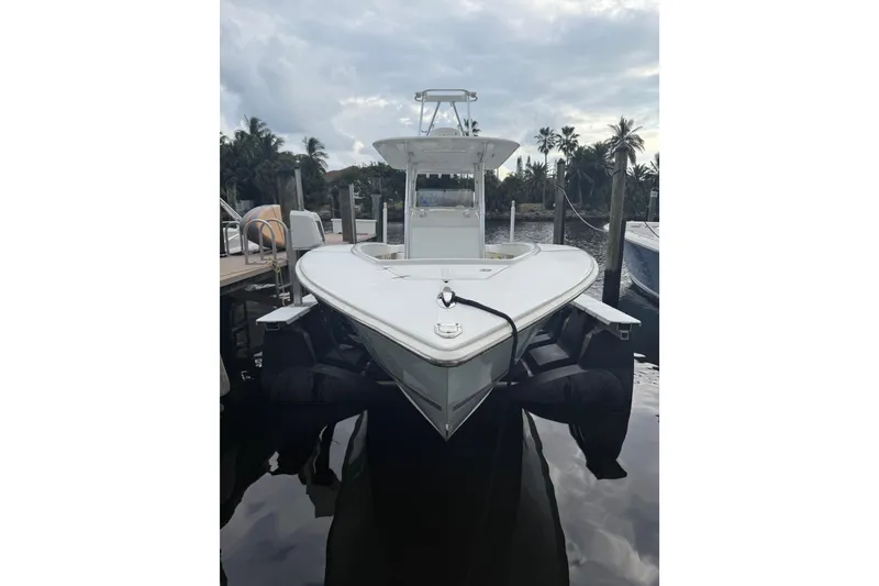 Slide: The Image of 2005 Jupiter 31 Center Console boat docked by palm trees under cloudy sky. - 12