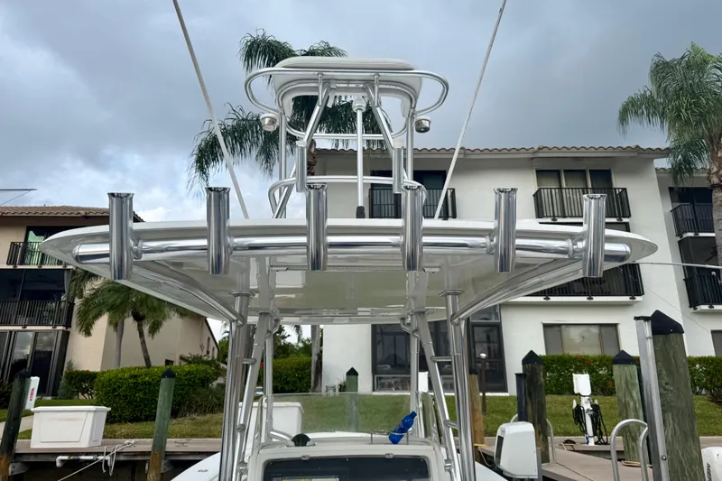 Slide: The Image of 2005 Jupiter 31 Center Console boat with rod holders, docked near waterfront homes. - 13