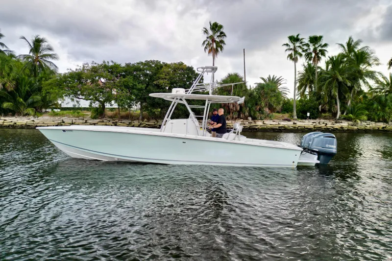 Slide: The Image of 2005 Jupiter 31 Center Console boat on water, surrounded by palm trees. - 9
