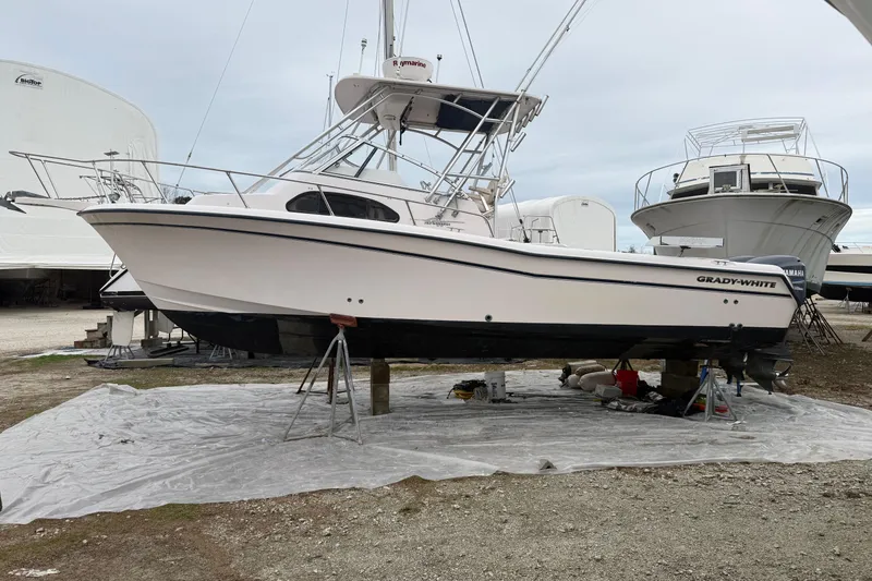 Slide: The Image of 2002 Grady-White Sailfish 282 boat on stands, clear blue sky background. - 23