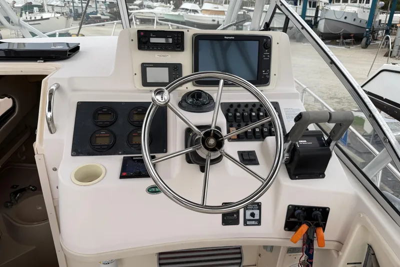 Slide: The Image of 2002 Grady-White Sailfish 282 boat dashboard with steering wheel and navigation instruments. - 7