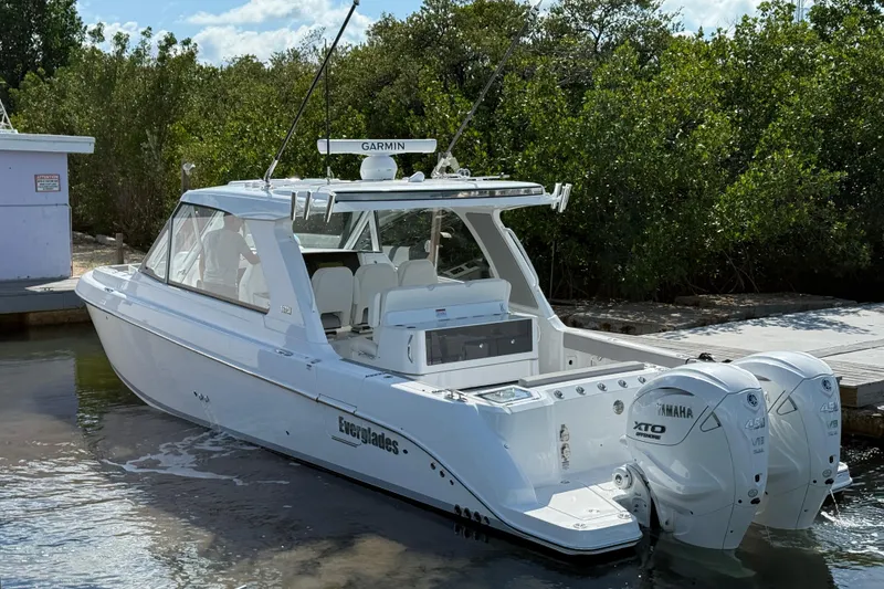 Slide: The Image of 2026 Everglades 367 CX boat with Yamaha engines docked near lush greenery. - 18