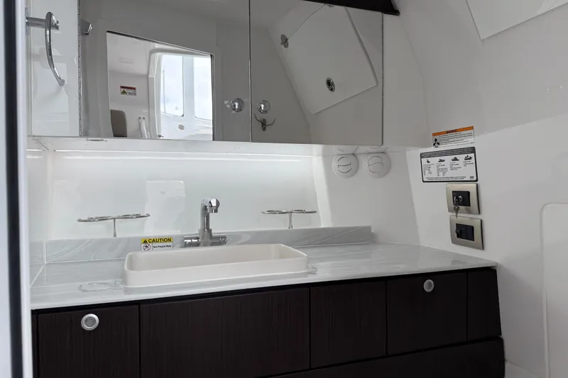 Slide: The Image of Modern bathroom interior of 2026 Everglades 367 CX boat, featuring sleek sink and mirror. - 44