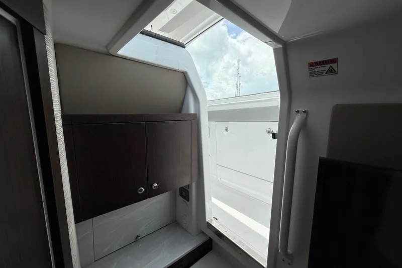 Slide: The Image of Interior view of 2026 Everglades 367 CX boat, featuring sleek cabinetry and open hatch. - 47