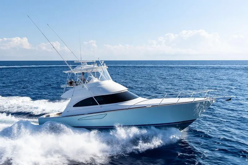 Slide: The Image of 2022 Viking 48 Convertible yacht cruising on open sea under clear skies. - 12