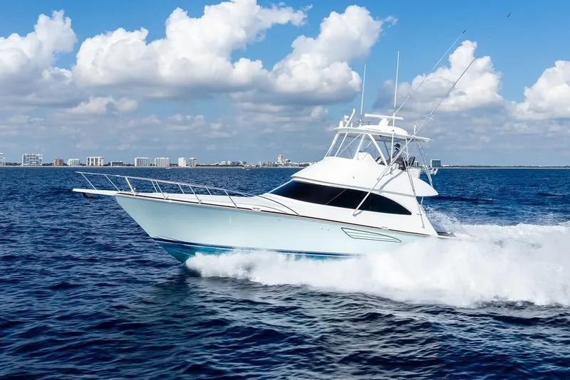 Slide: The Image of 2022 Viking 48 Convertible yacht cruising on open sea under blue sky. - 14