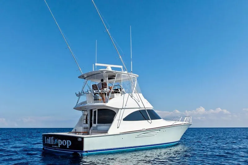 Slide: The Image of 2022 Viking 48 Convertible yacht on open sea under clear blue sky. - 2