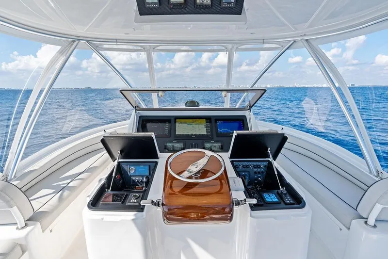 Slide: The Image of Cockpit of 2022 Viking 48 Convertible yacht with ocean view and navigation equipment. - 26