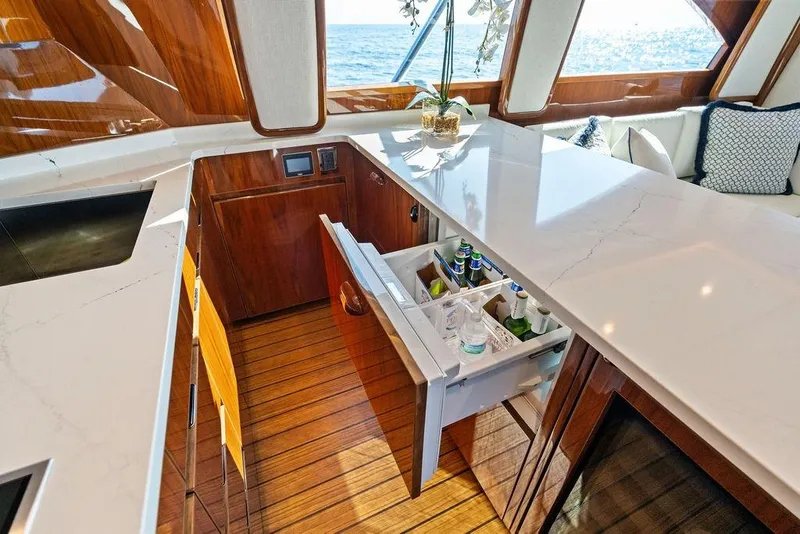 Slide: The Image of Luxurious 2022 Viking 48 Convertible yacht interior with open drawer fridge and elegant wood finish. - 48