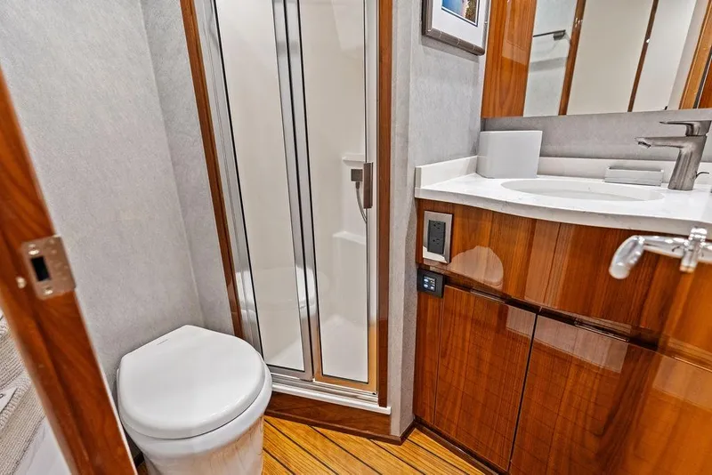 Slide: The Image of Luxurious bathroom in 2022 Viking 48 Convertible yacht with modern fixtures and wood accents. - 62