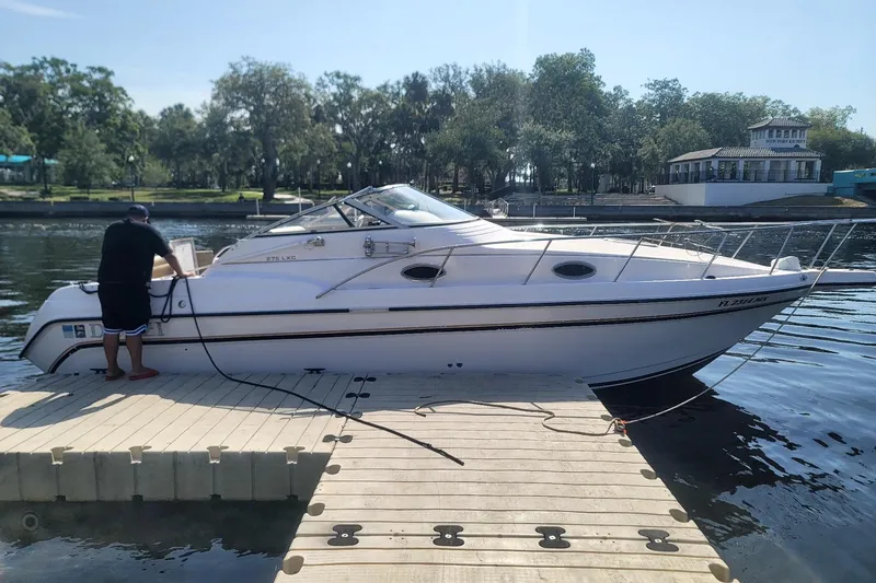 The Image of 1997 Donzi 275 LXC boat docked at a marina with a person on the pier. - 1