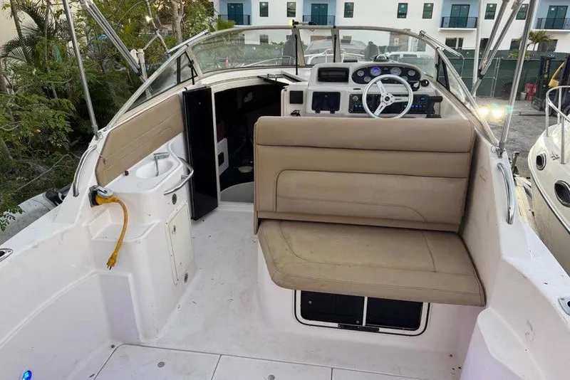 Slide: The Image of 1997 Donzi 275 LXC boat interior with beige seating and steering console. - 2