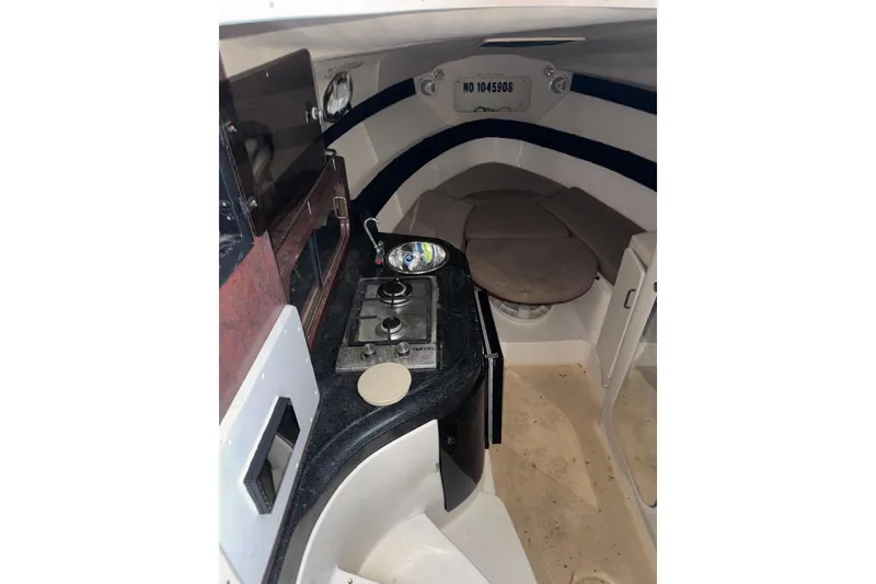 Slide: The Image of Interior of a 1997 Donzi 275 LXC boat featuring a compact kitchen and seating area. - 4